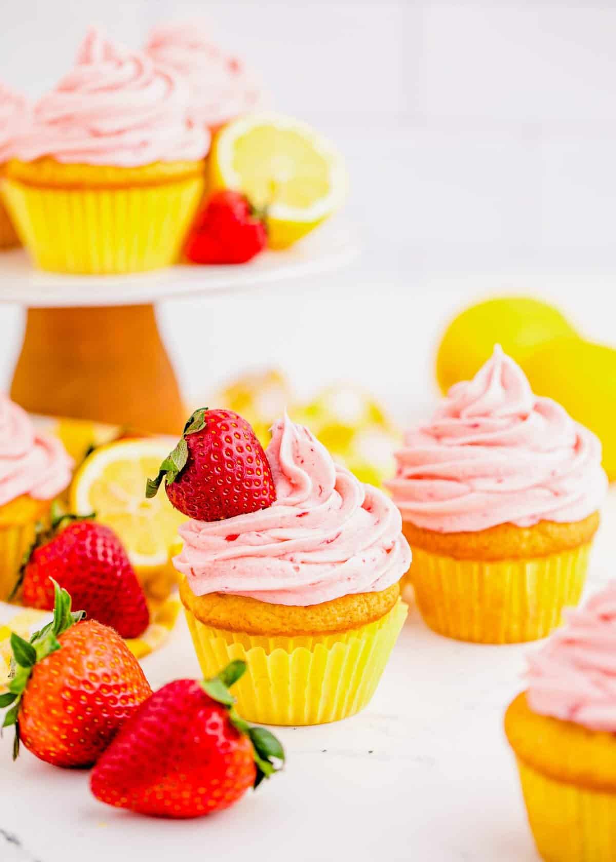 Strawberry lemonade cupcakes on table and cake stand