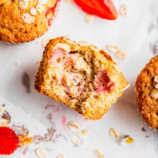 Strawberry oatmeal breakfast muffins, with one bitten into and on its side
