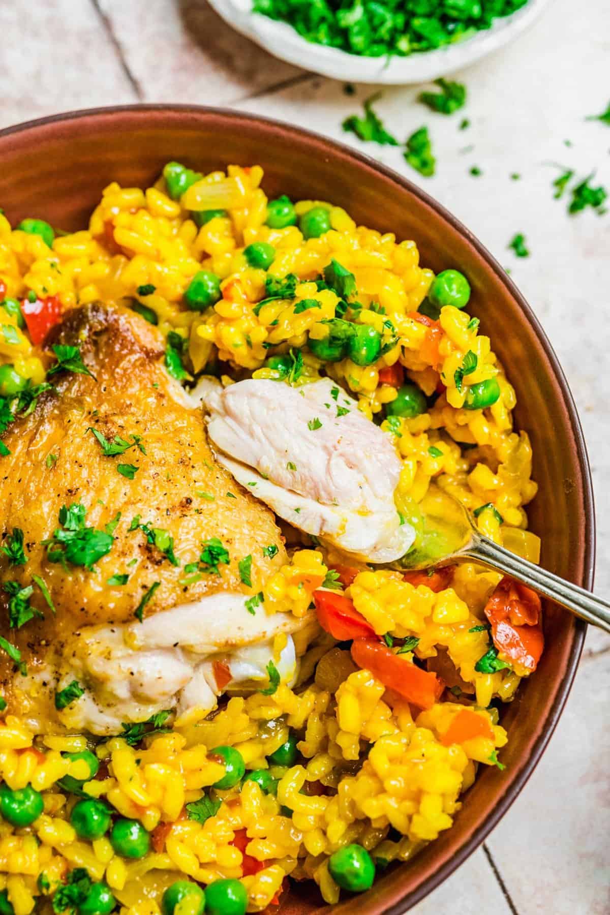 Overhead view of arroz con pollo in bowl with forkful of chicken