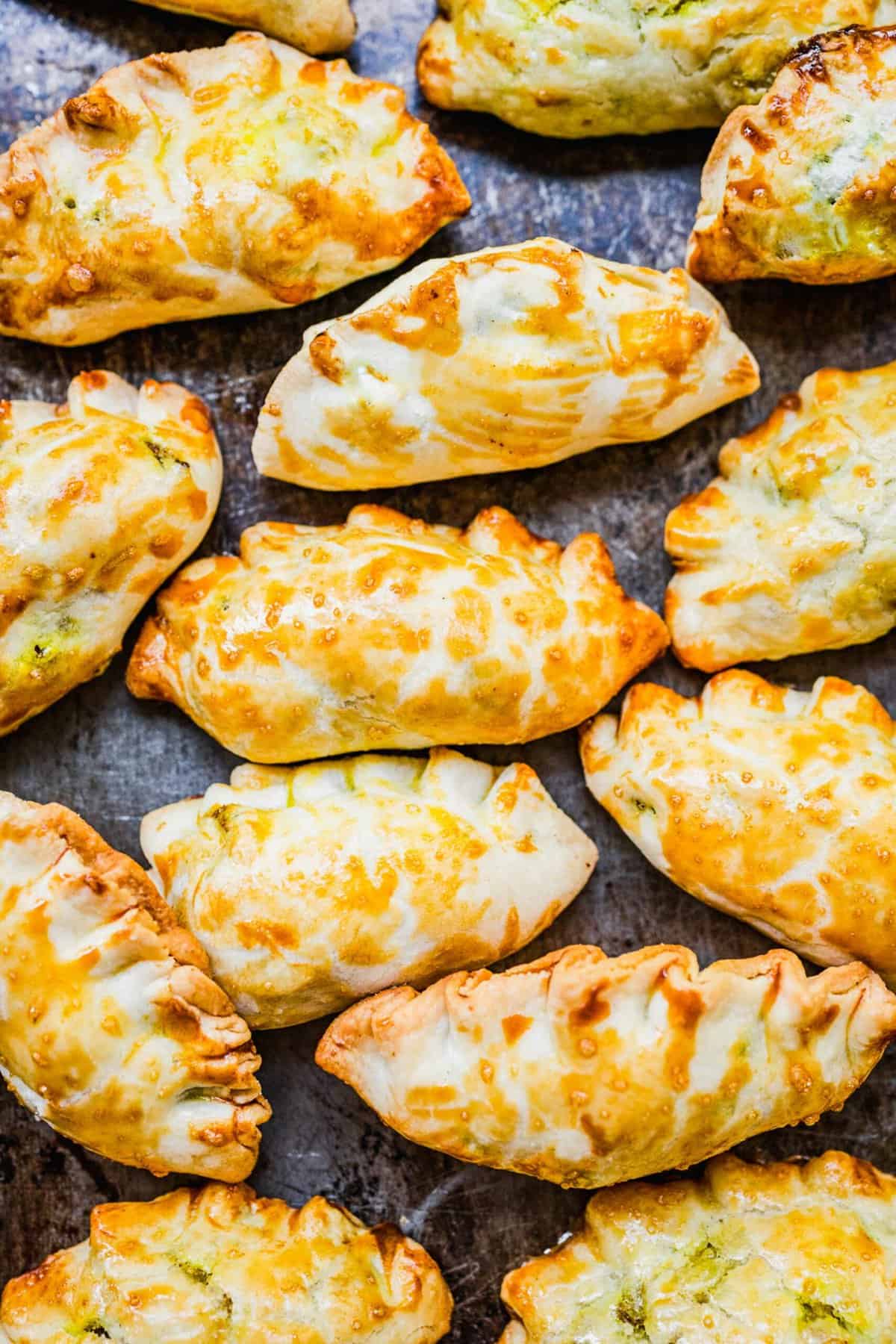 Overhead view of baked Chinese curry pockets on sheet pan