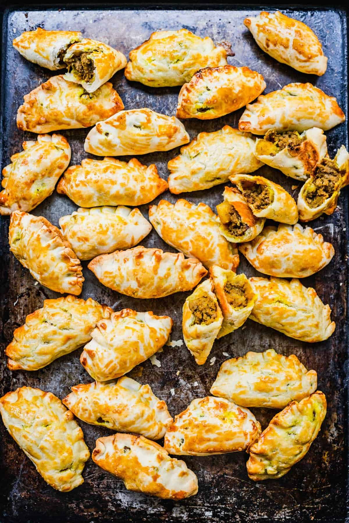 Overhead view of Chinese curry pockets on baking sheet.