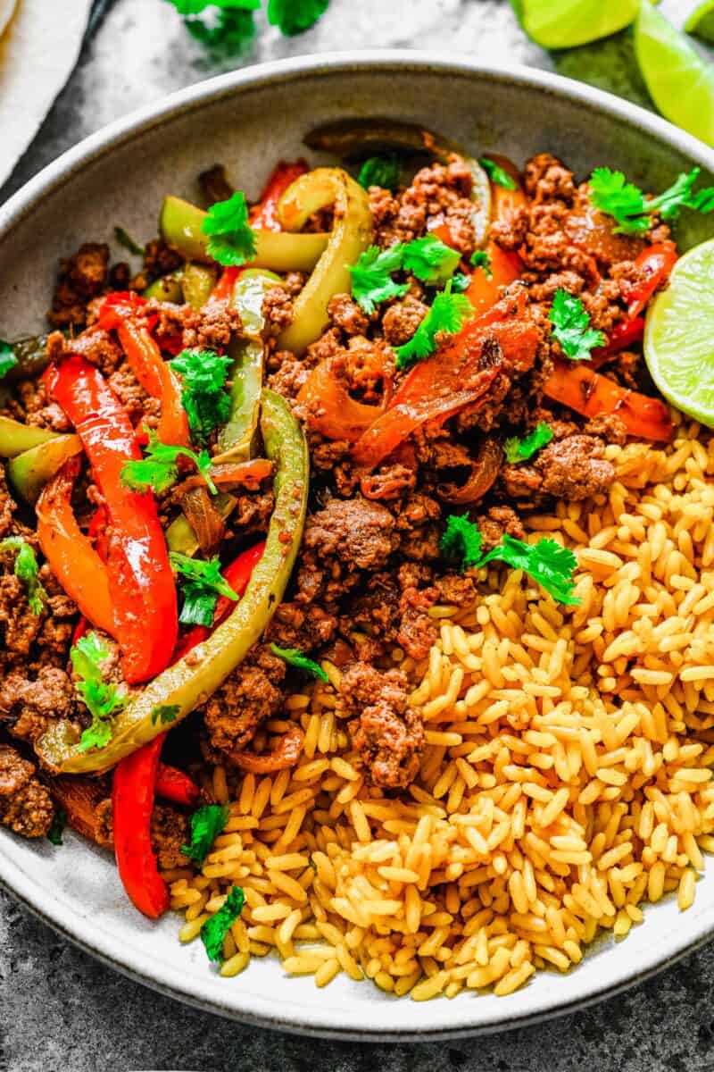 Rice and ground beef fajitas are topped with a sprinkle of fresh cilantro. 