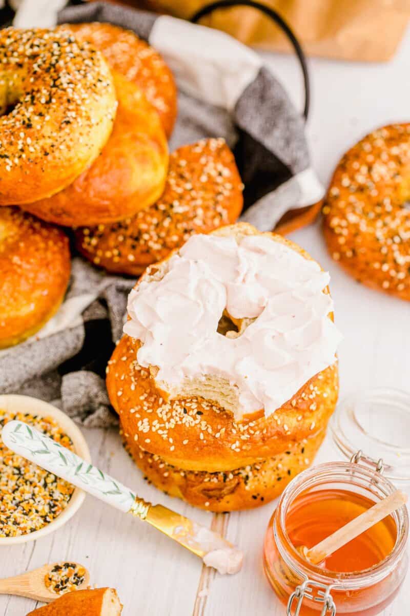 A halved bagel is topped with cream cheese. 