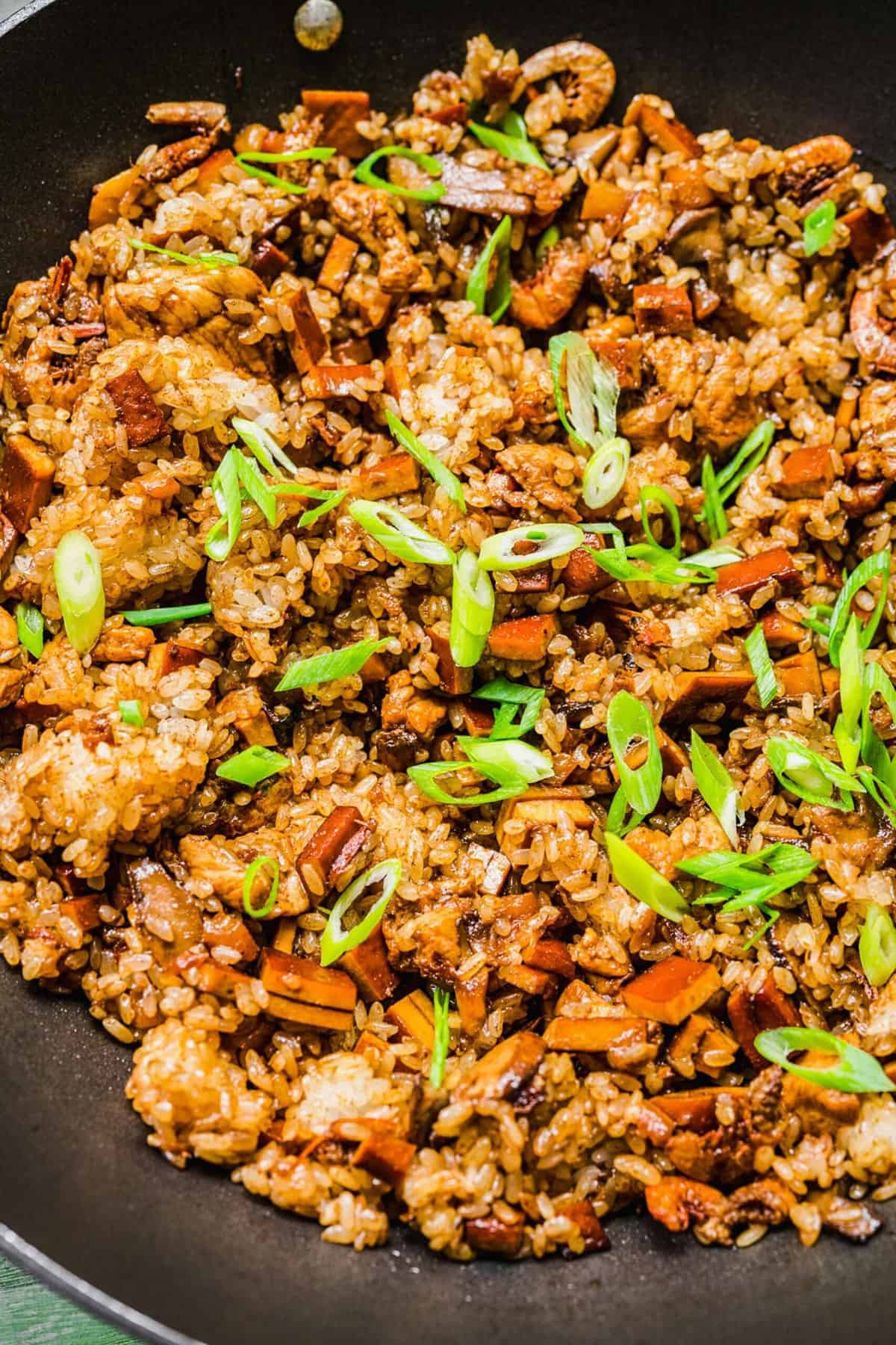 Skillet of sticky rice garnished with scallions