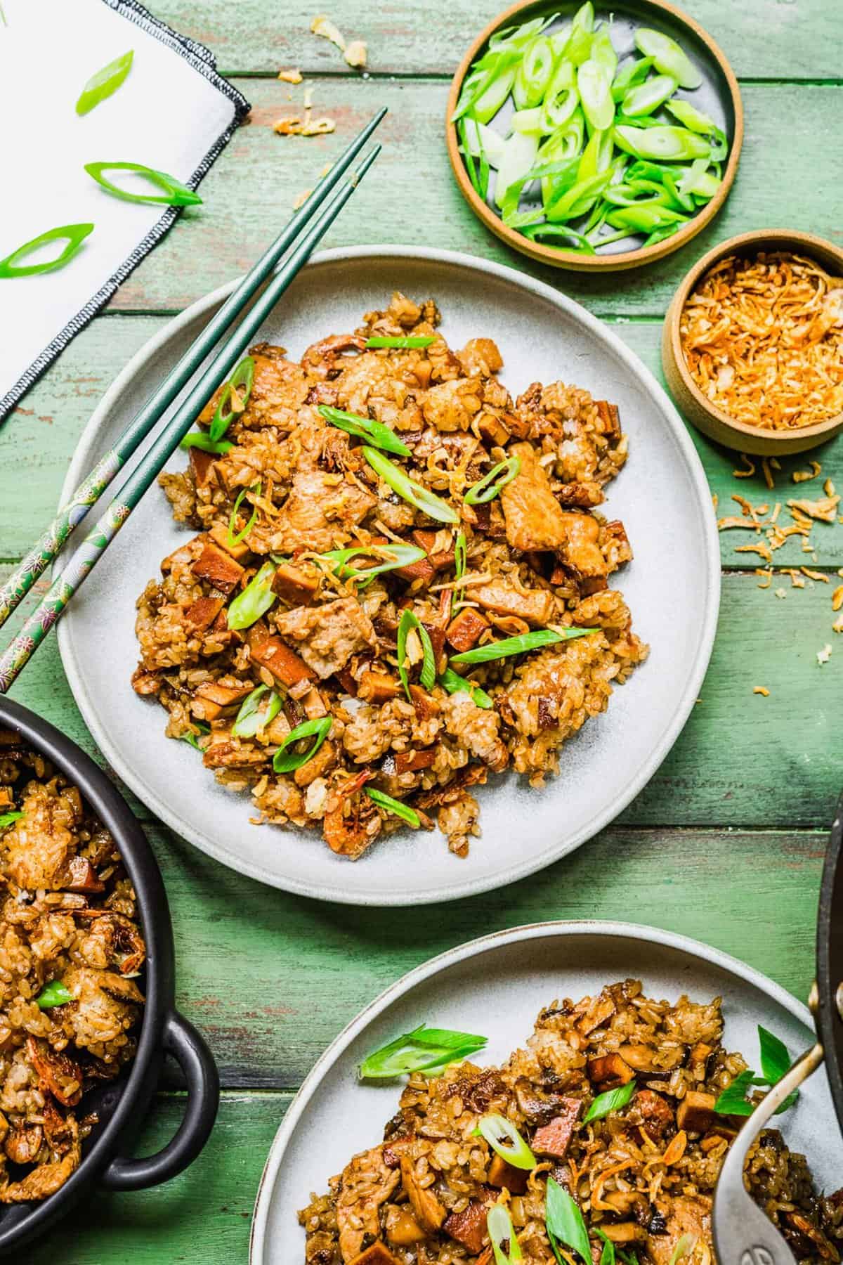 2 plates of sticky rice with bowls of garnishes