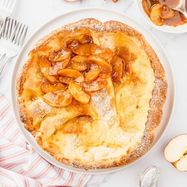 Fall table is set with an Apple Cinnamon Dutch Baby topped with apple compote in the center of table.