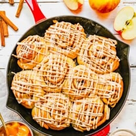 Apple pie cinnamon rolls baked in a cast iron skillet.