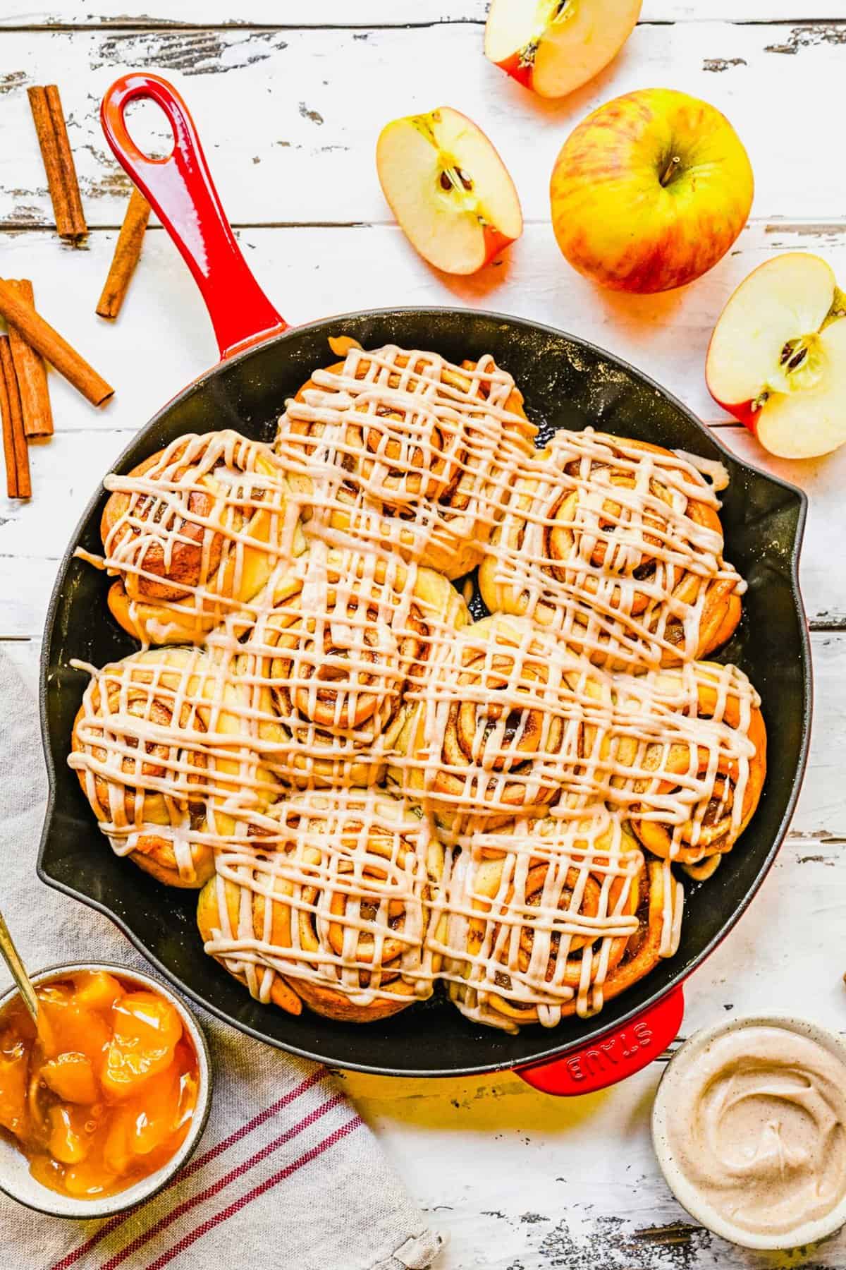 Apple pie cinnamon rolls baked in a cast iron skillet.