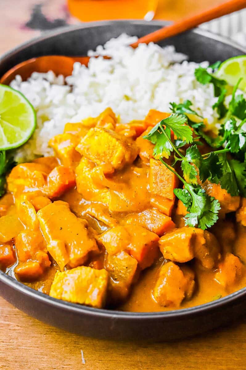 Limes and cilantro garnish a serving of pumpkin coconut curry. 