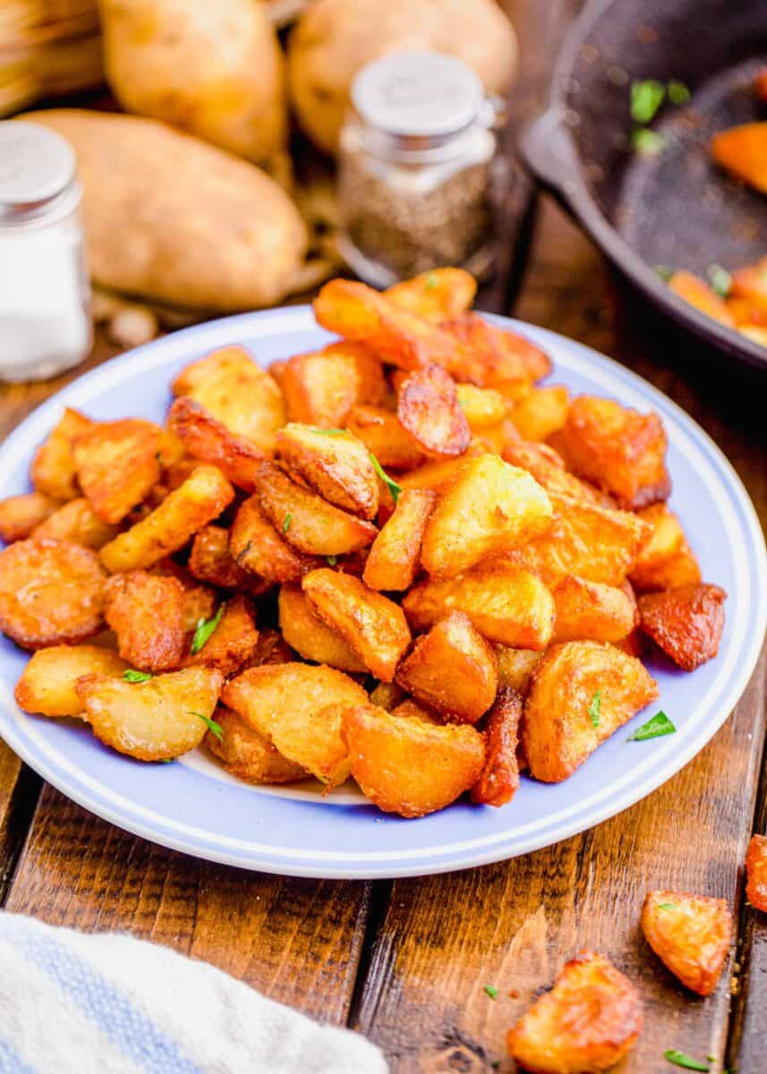 duck fat potatoes plated in a pile on a light blue plate