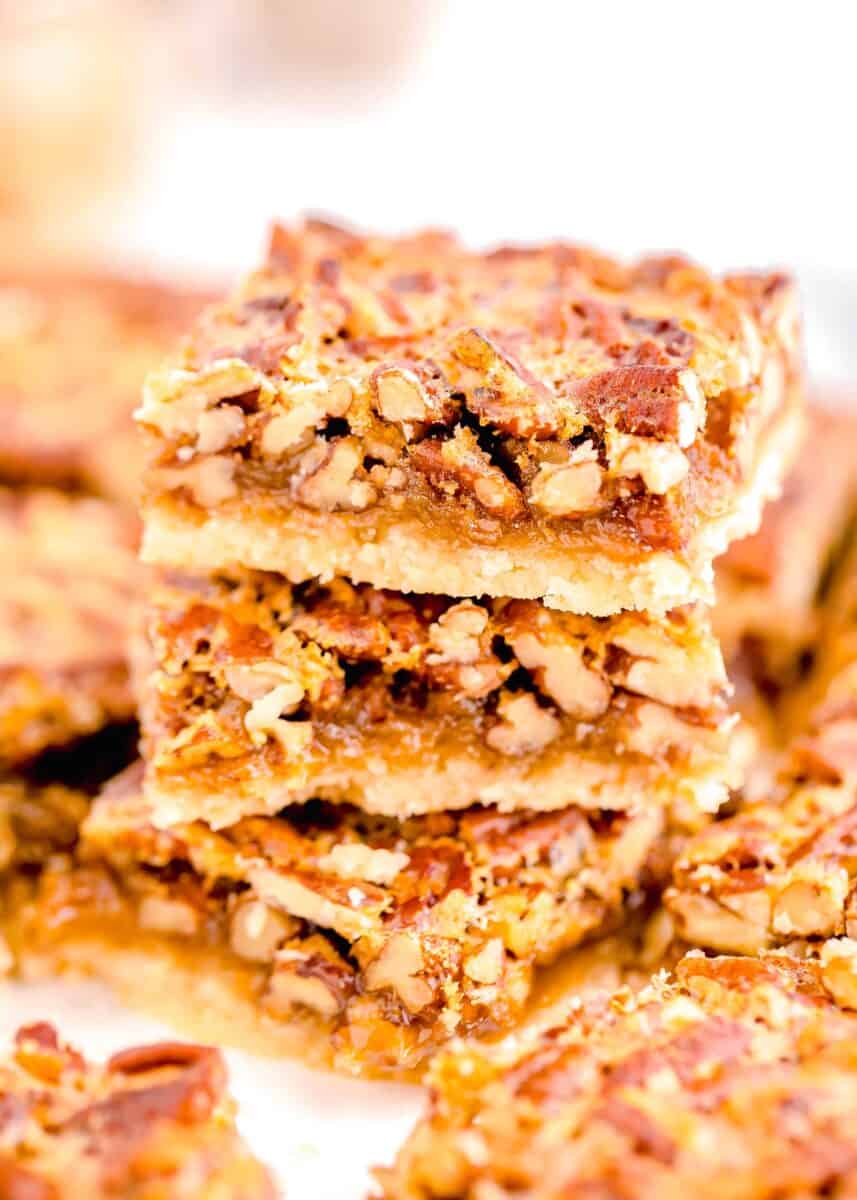 pecan pie bars stacked on top of each other and sliced to see the insides