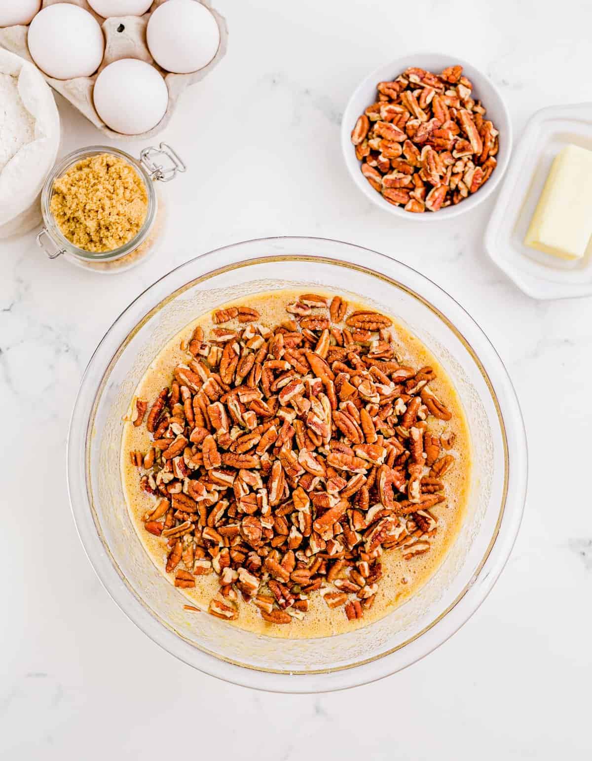 chopped pecans on top of the filling in a clear bowl