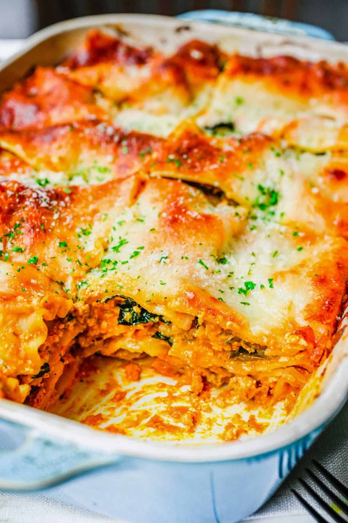 Close up of the corner of a baking tray with pumpkin lasagna, with the corner piece removed