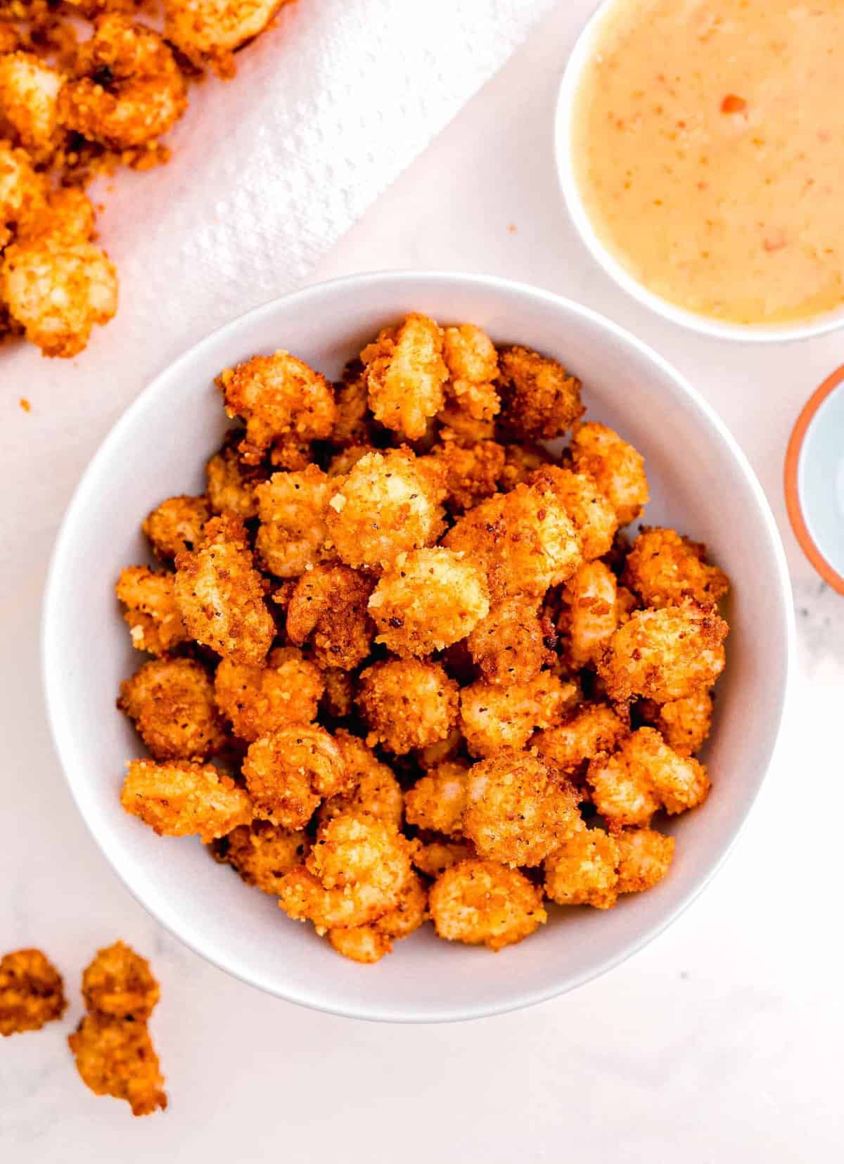 the fried shrimp in a large white bowl next to the mayo mixture