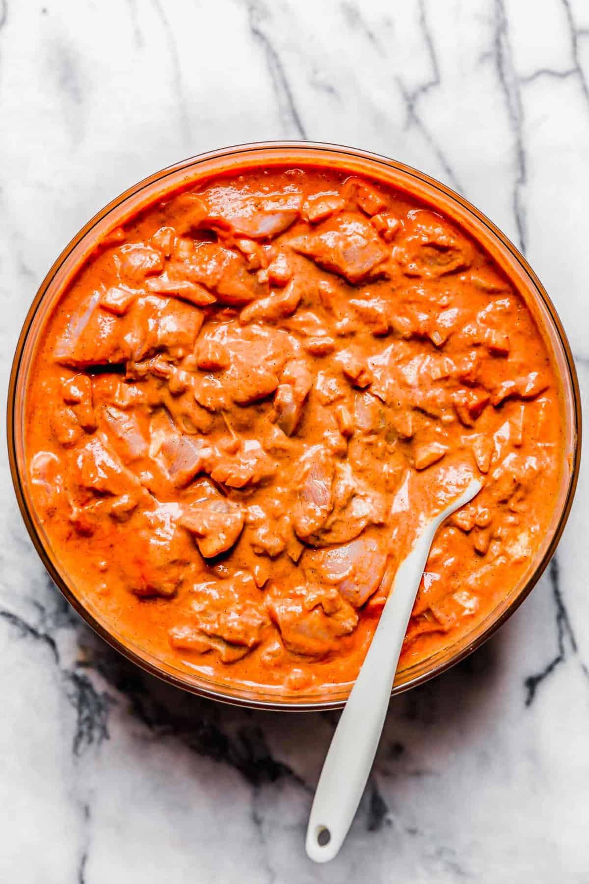 chicken tikka masala mixture in a large clear bowl