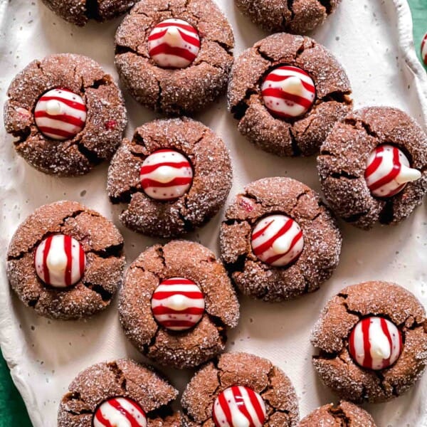 An oval tray filled with chocolate peppermint kiss cookies, topped with Hershey's peppermint kisses