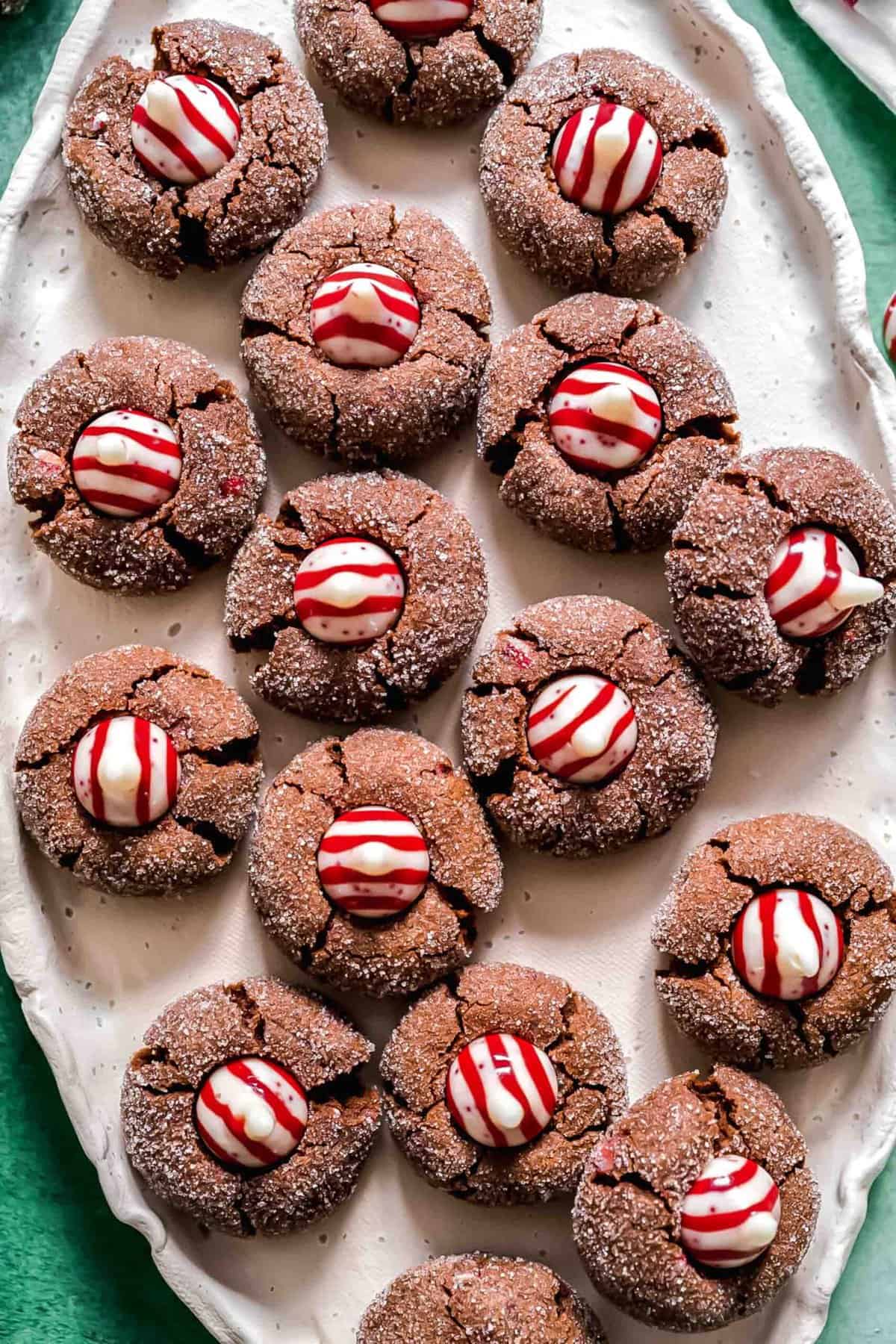 An oval tray filled with chocolate peppermint kiss cookies, topped with Hershey's peppermint kisses