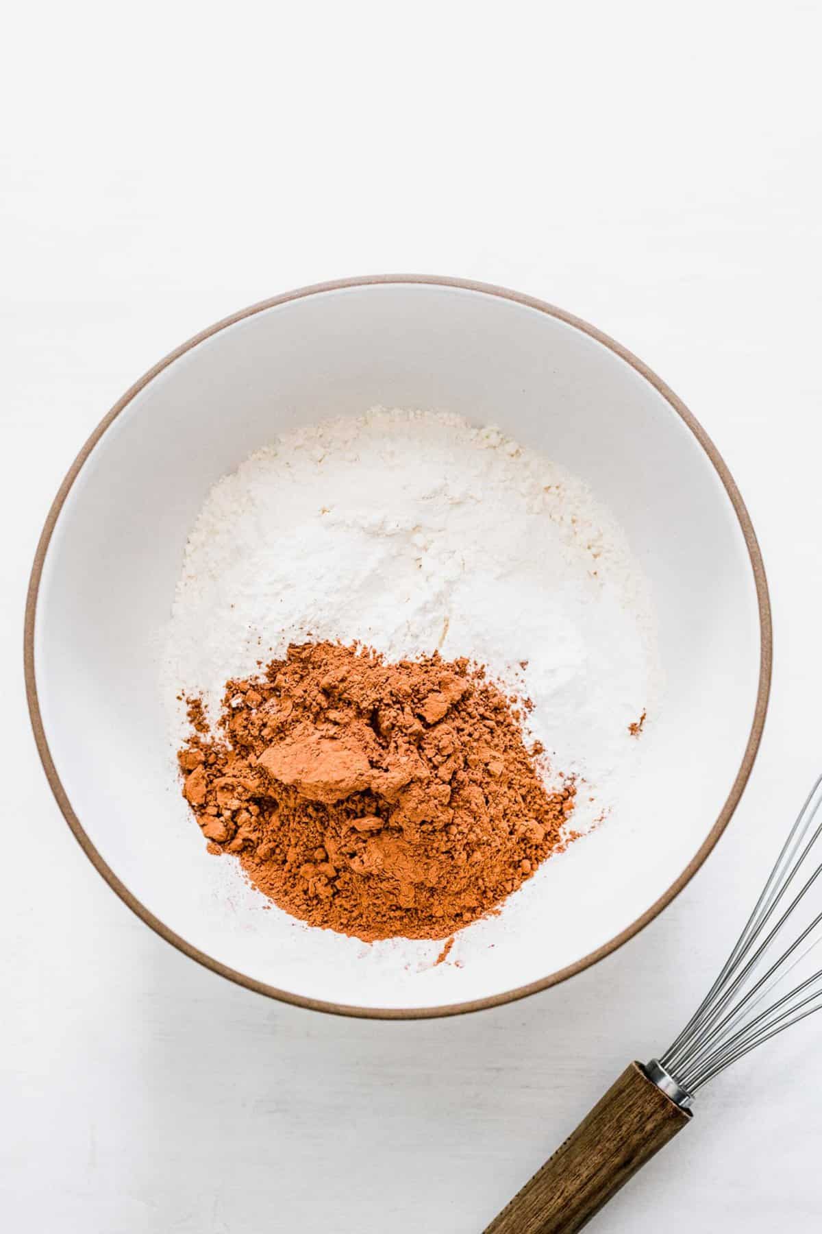 A mixing bowl with flour, cocoa powder, baking powder, and salt
