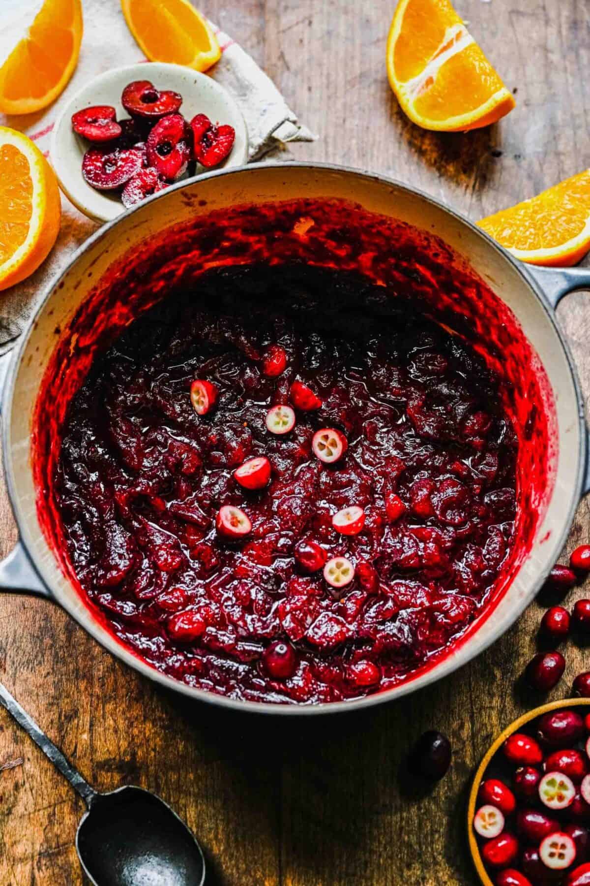 A pot filled with cranberry cherry compote, topped with fresh cranberries