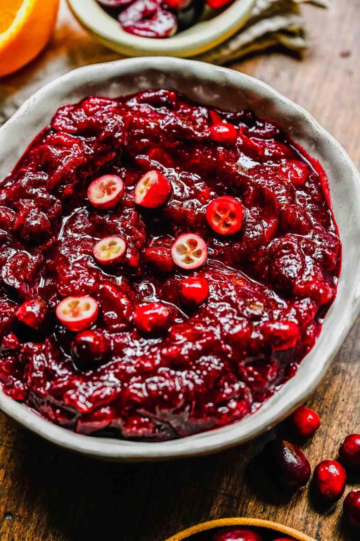 Close up of a bowl of cranberry cherry compote topped with slices of fresh cranberry