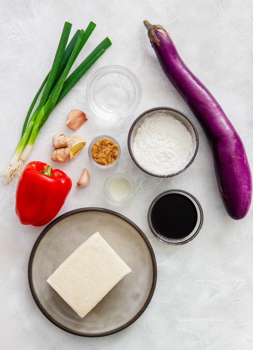 ingredients for eggplant tofu: water, cornstarch, soy sauce, eggplant, brown sugar, rice vinegar, garlic, ginger, scallions, red bell pepper, and tofu