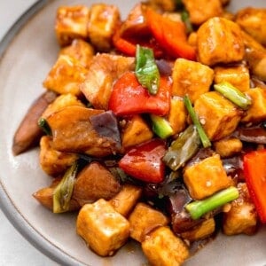 up close image of eggplant tofu on a grey ceramic plate