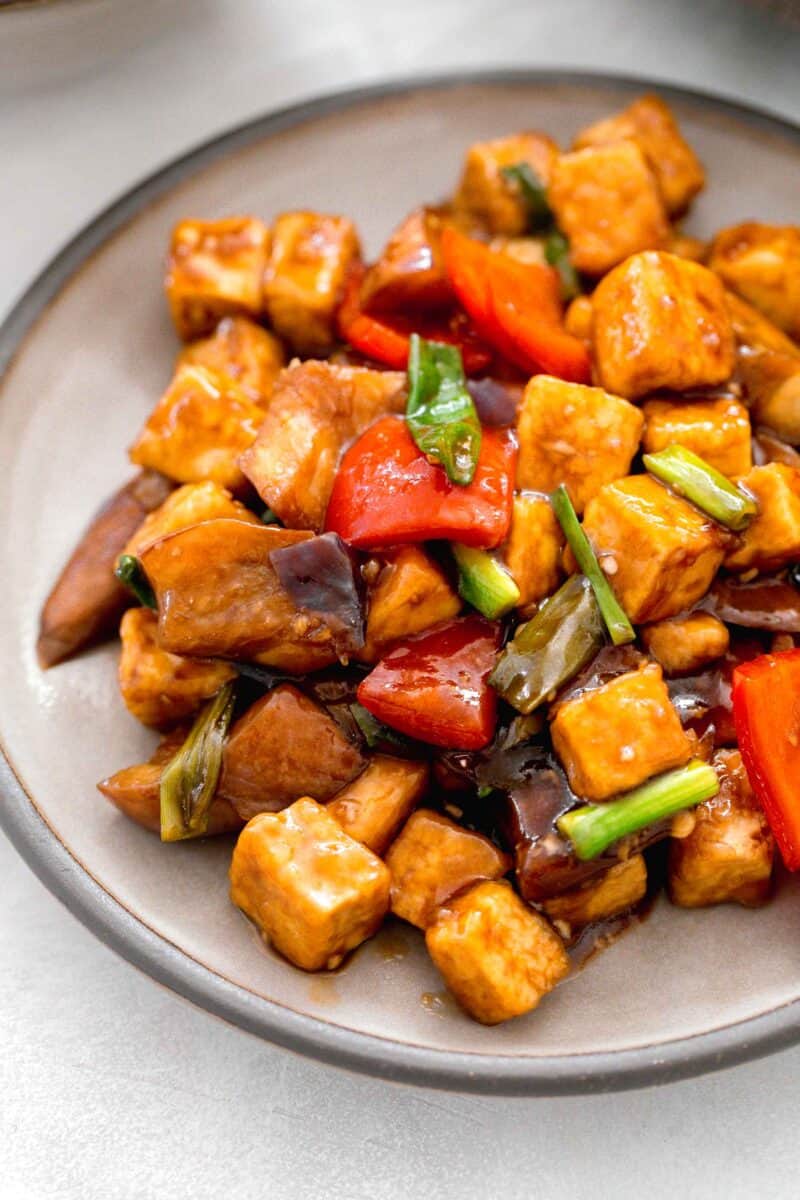 up close image of eggplant tofu on a grey ceramic plate