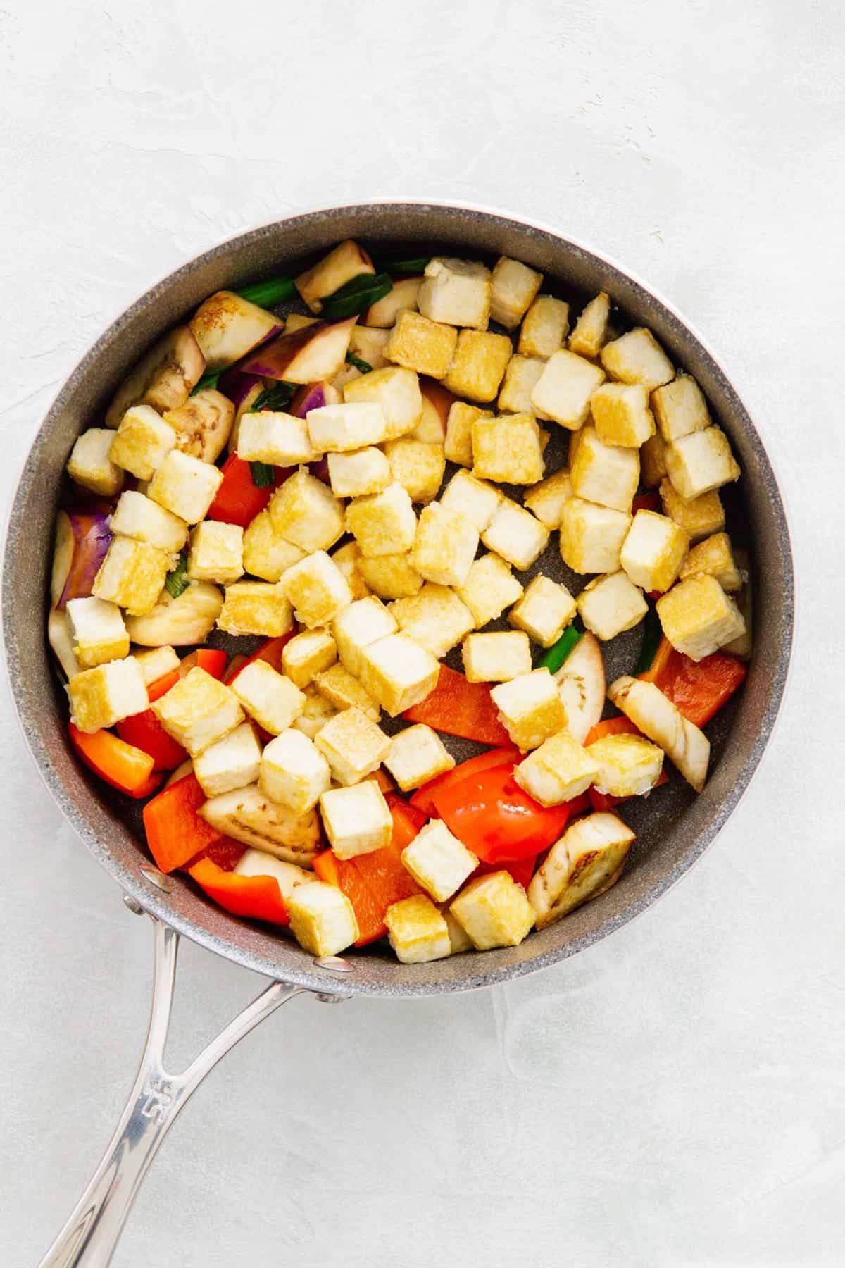 crisped tofu added to the skillet with the eggplant, red bell pepper, and scallions