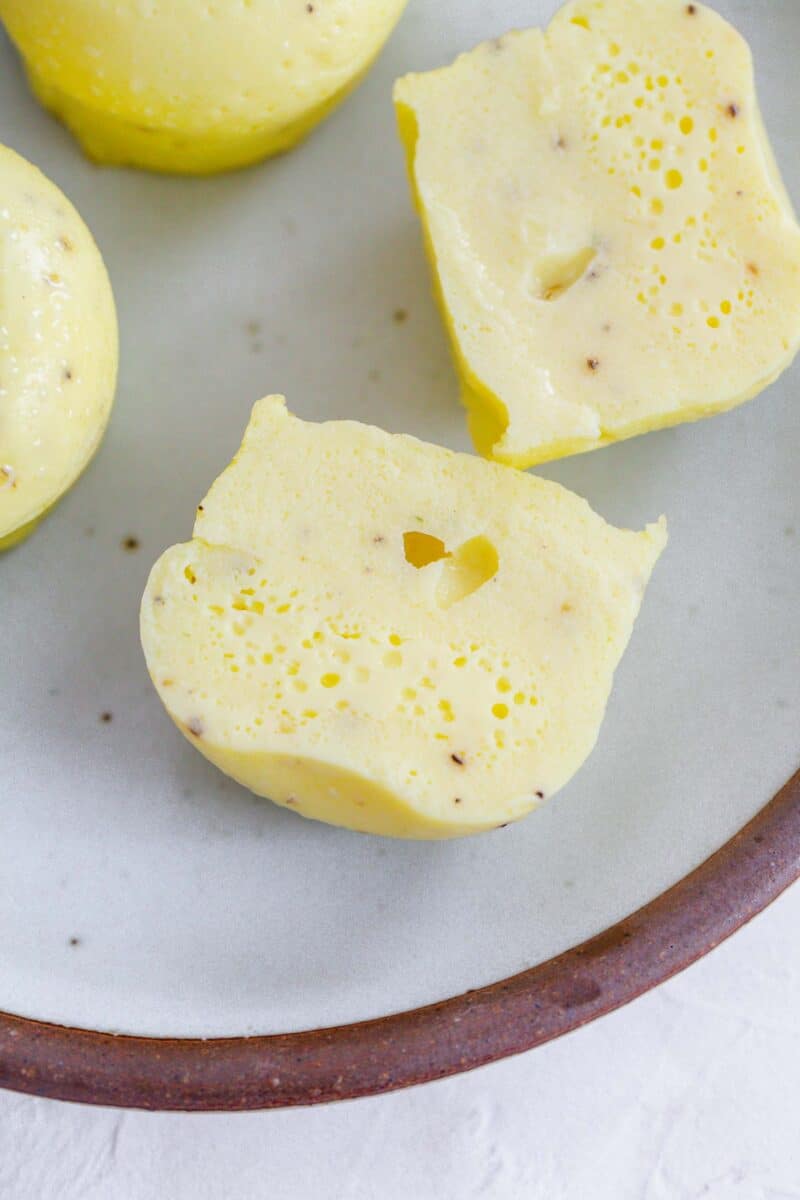 instant pot egg bites sliced in half on a ceramic plate with a brown rim