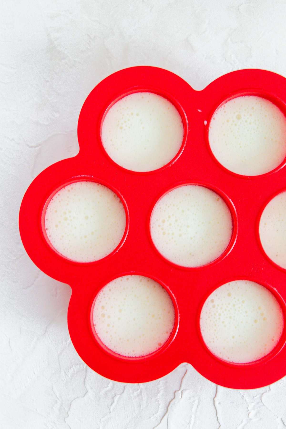 red silicone egg mold filled with egg white mixture