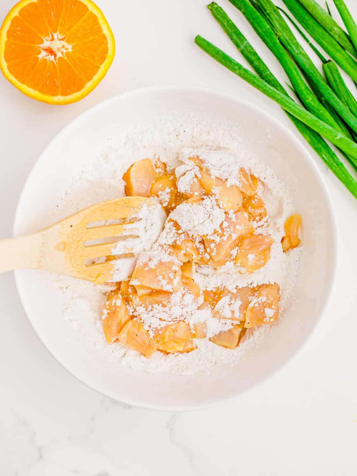 Coating egg-dipped chicken in flour mixture