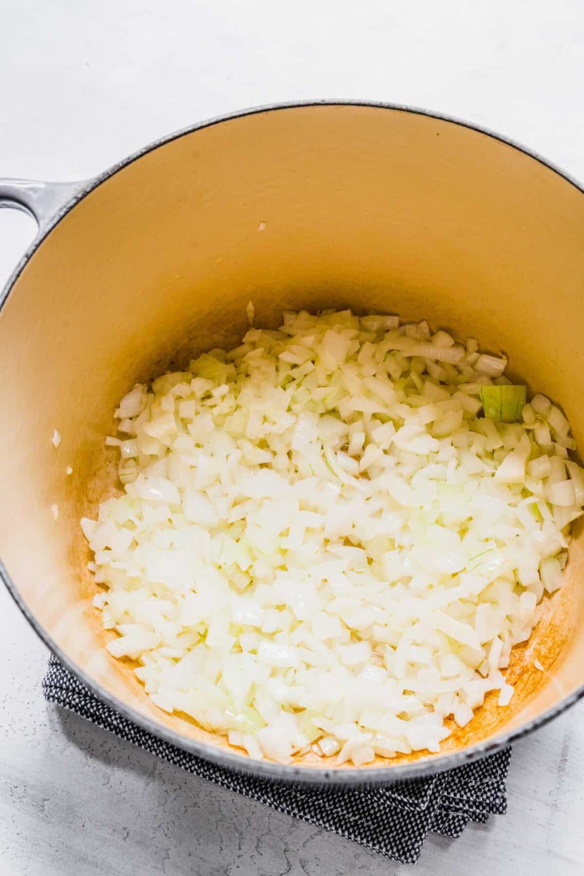 A pot with chopped onions and butter in it