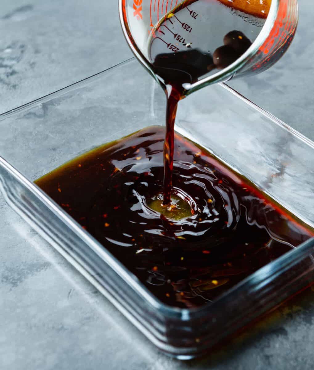 pouring marinade into shallow glass rectangular container