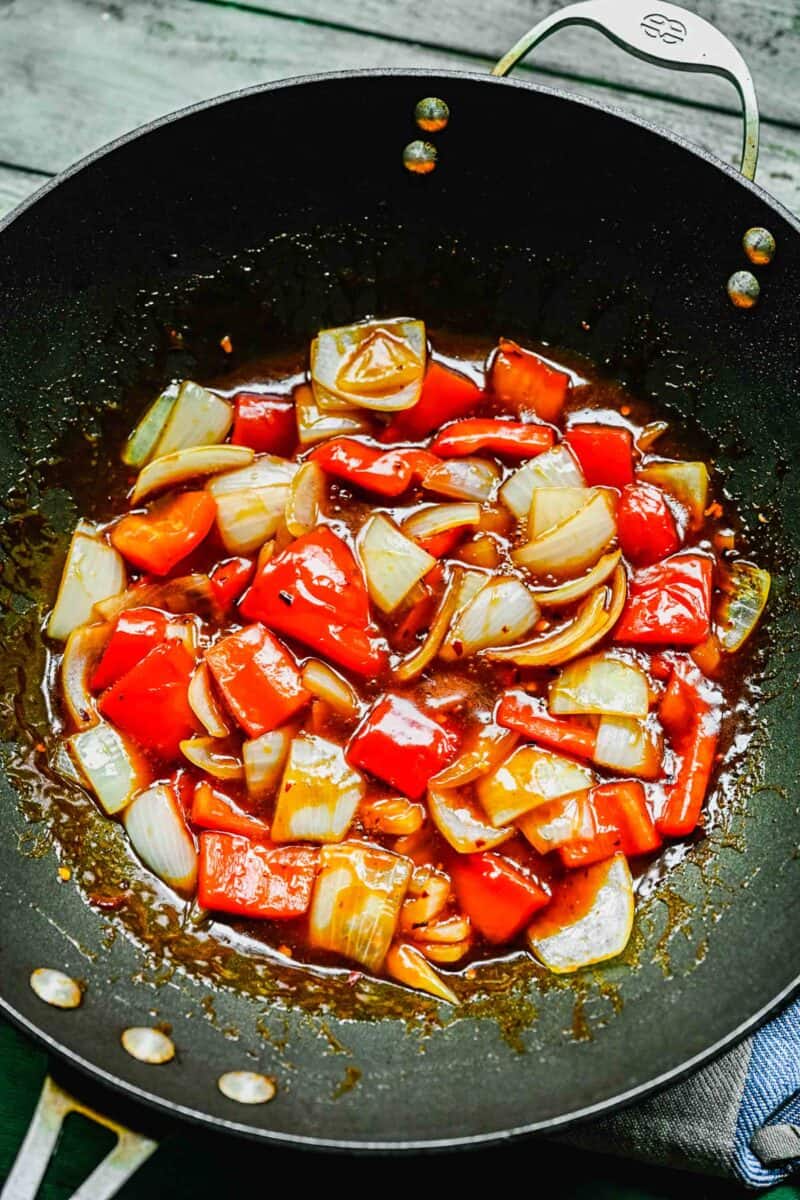 Bell peppers and onions in a wok with Beijing beef sauce.
