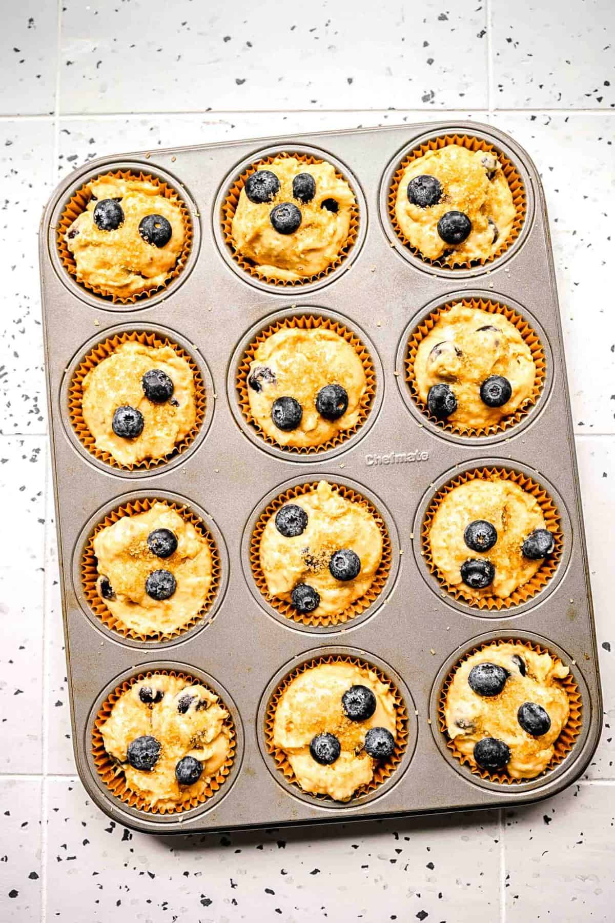 Banana blueberry muffin batter in muffin tins ready to be baked.
