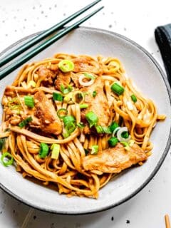 Chicken lo mein served in a bowl with chopstips.