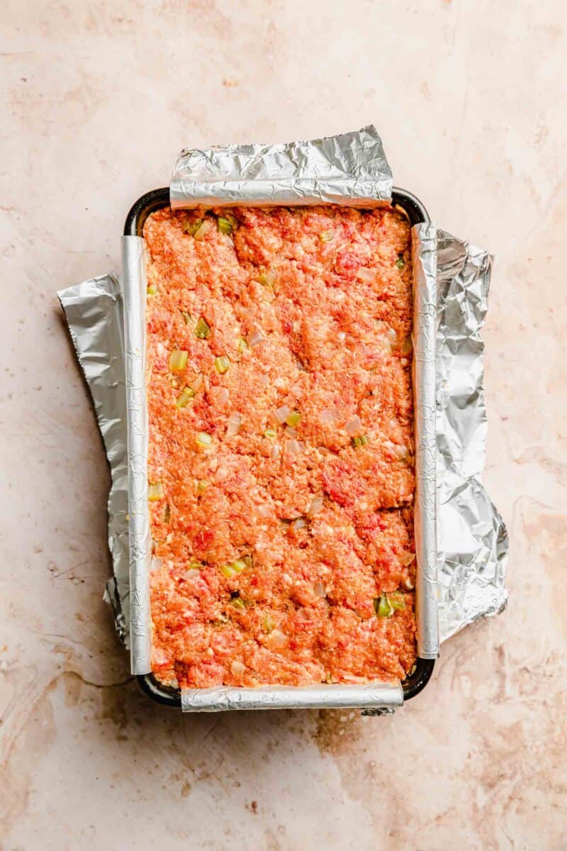 Classic meatloaf assembled in a loaf pan before glazing and baking.