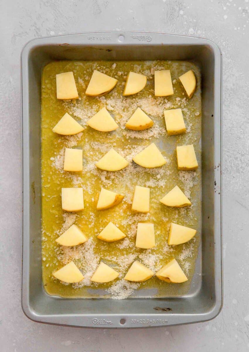 quartered yellow potatoes in an even layer on top of the butter-cheese mixture in the light metal baking 9x13" pan