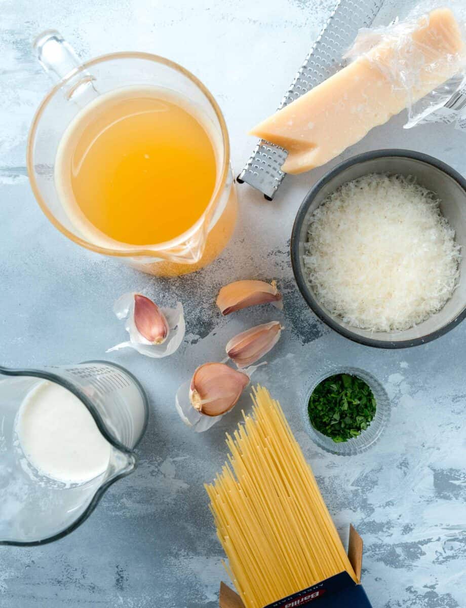 ingredients for garlic parmesan pasta: chicken stock, parmesan cheese, fresh parsley, angel hair pasta, garlic, and heavy cream