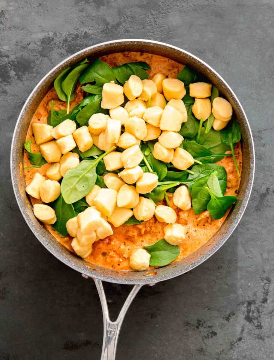 fresh potato gnocchi being added into the skillet