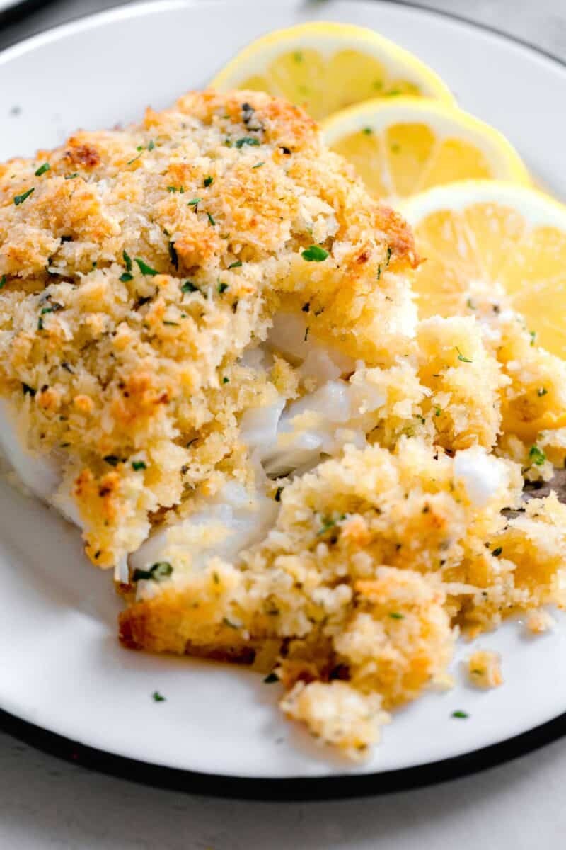 tender, flakey, cod filet split in half with a fork to show the inside of the panko parmesan cod