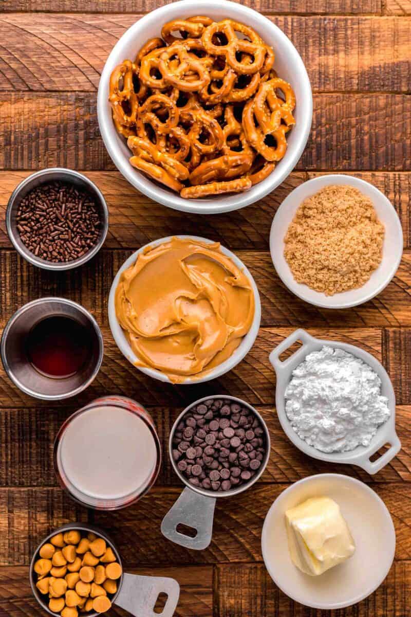 ingredients for peanut butter pretzel bites: mini pretzels, brown sugar, powdered sugar, butter, butterscotch and chocolate chip morsels, heavy cream, maple syrup, sprinkles, and creamy peanut butter