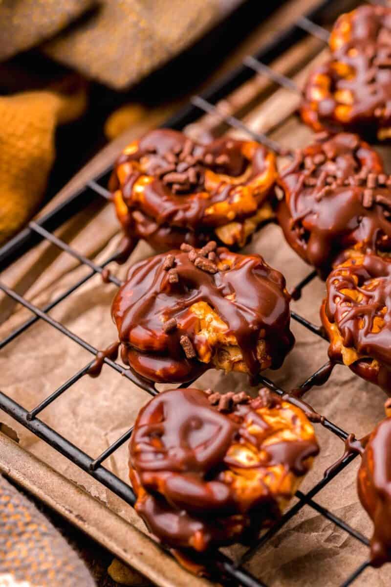 peanut butter pretzel bites with scattered chocolate drizzle on a wire baking sheet