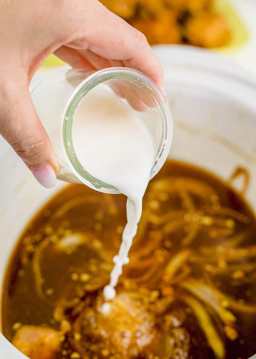 adding the cornstarch slurry to the chicken adobo sauce in the slow cooker