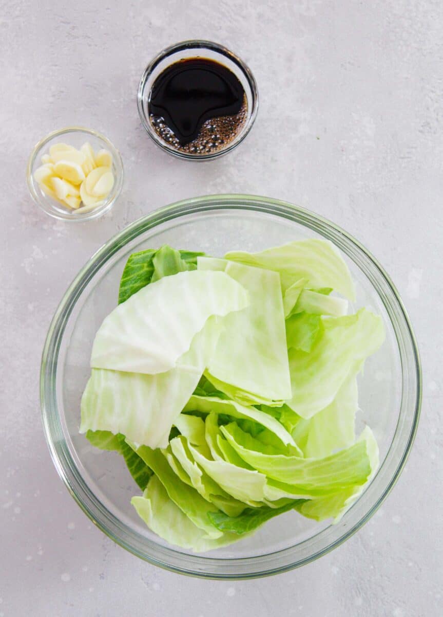 ingredients for stir fry cabbage: cabbage, soy sauce, and garlic slices
