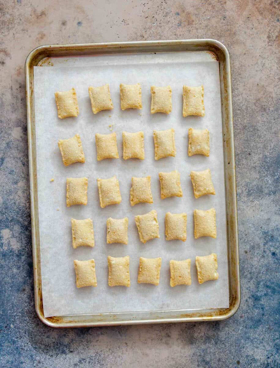 frozen pizza rolls on a parchment paper lined rimmed baking sheet