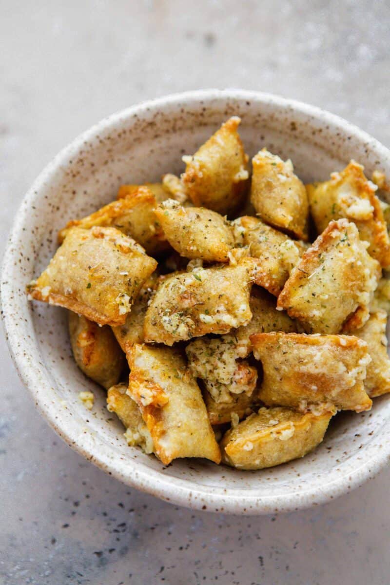 baked pizza rolls in a speckled ceramic bowl