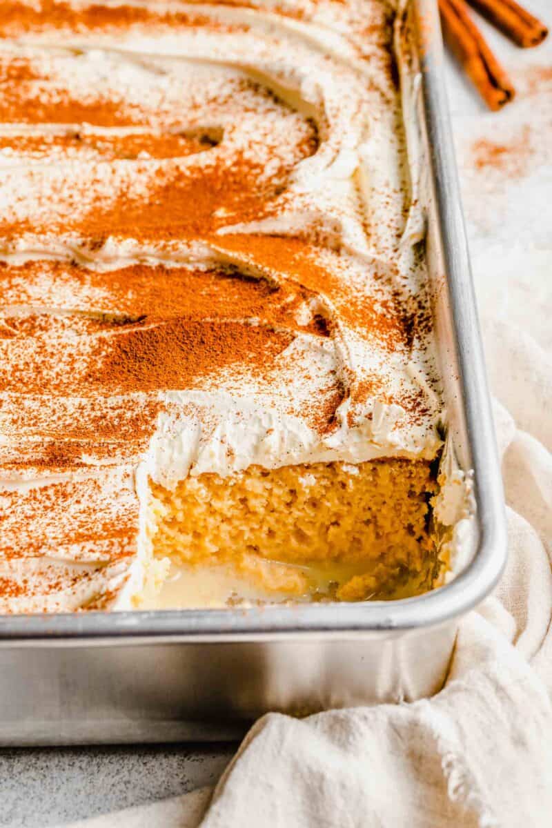 Prepared tres leches cake in a pan missing 1 slice.