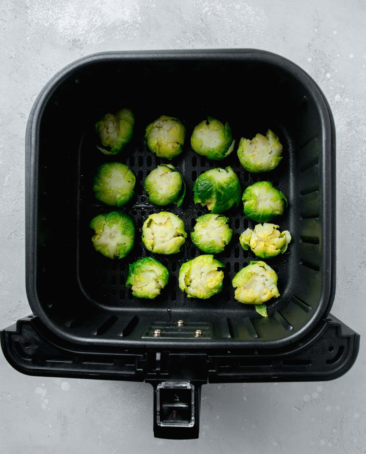 smashed brussels sprouts in basket of an air fryer