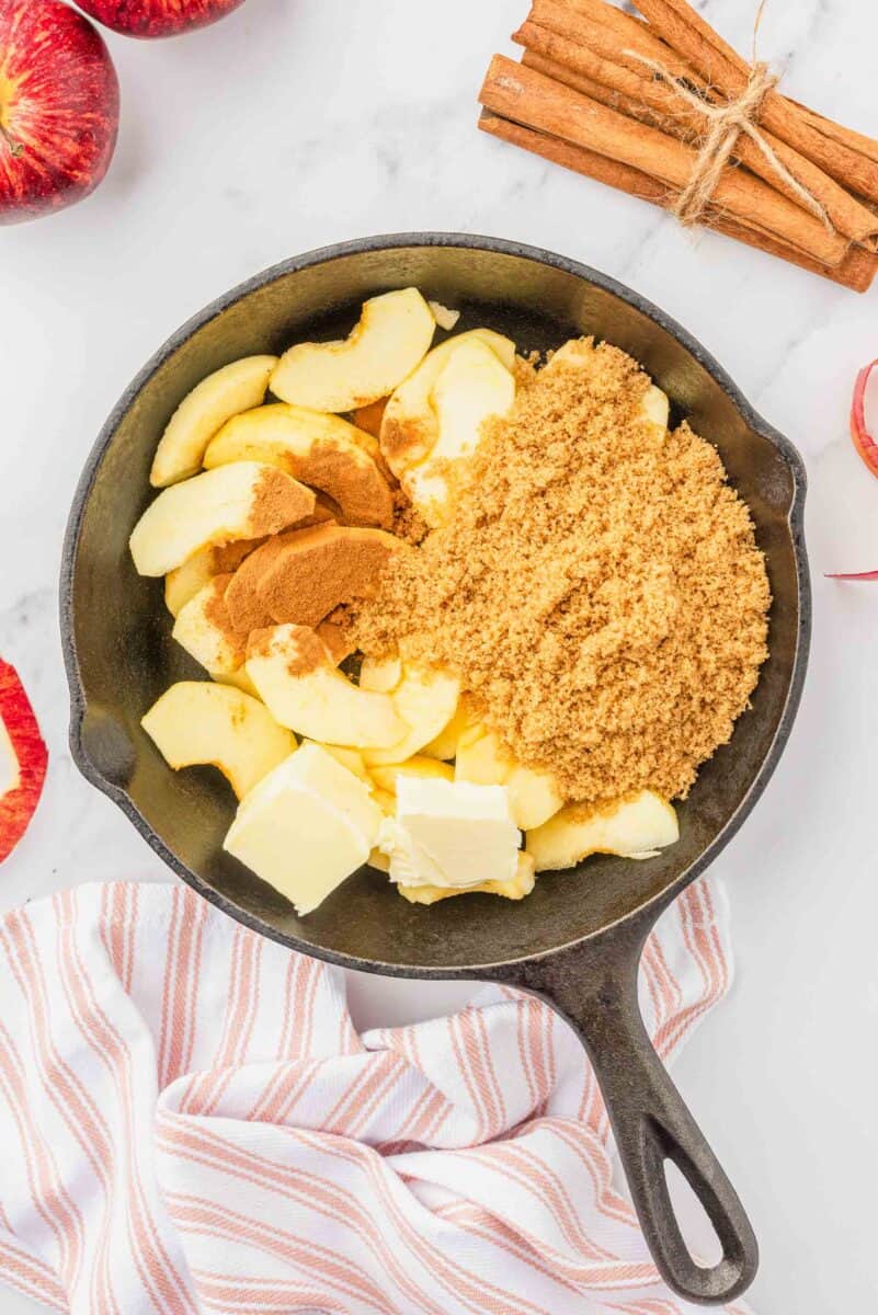 sliced apples, butter, cinnamon, and brown sugar in a cast iron skillet
